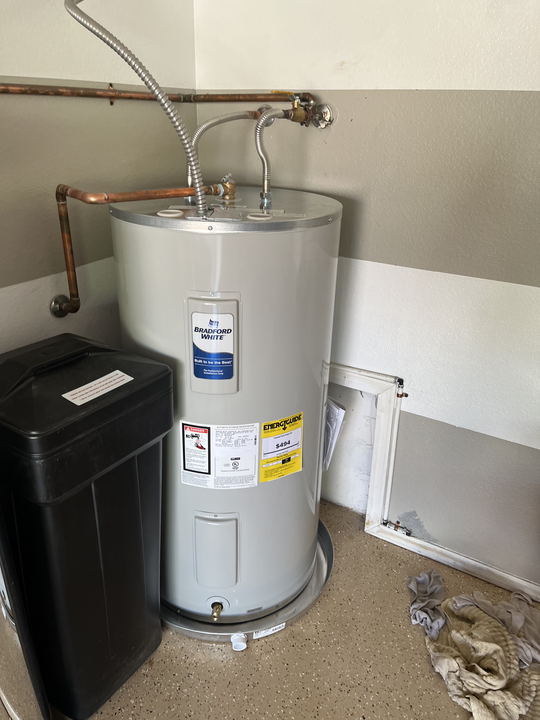 A standard tank water heater installed in a utility room.