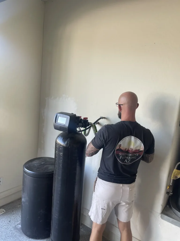 Water softener unit installed in a residential garage, showing clean plumbing connections.