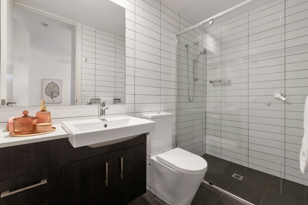 Modern bathroom with sink, toilet, and shower installed by a Gilbert AZ plumber.