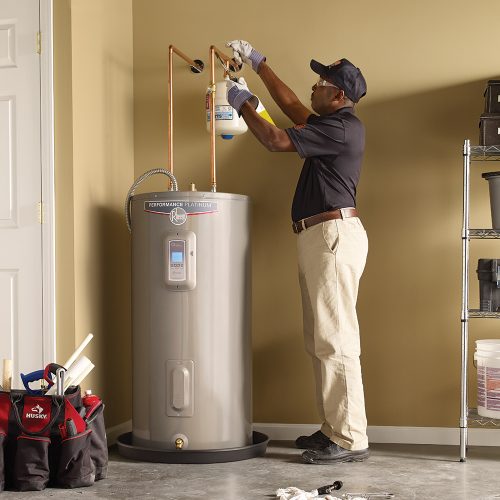 A plumber holding a wrench and a pipe.