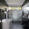 A bathroom being renovated, showing new tile being installed on the shower walls.