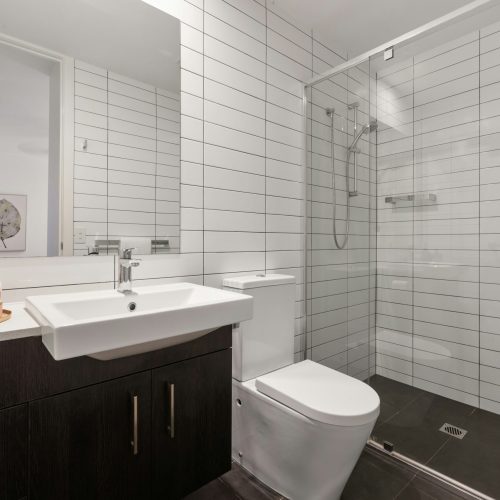 Modern bathroom with sink, toilet, and shower installed by a Gilbert AZ plumber.