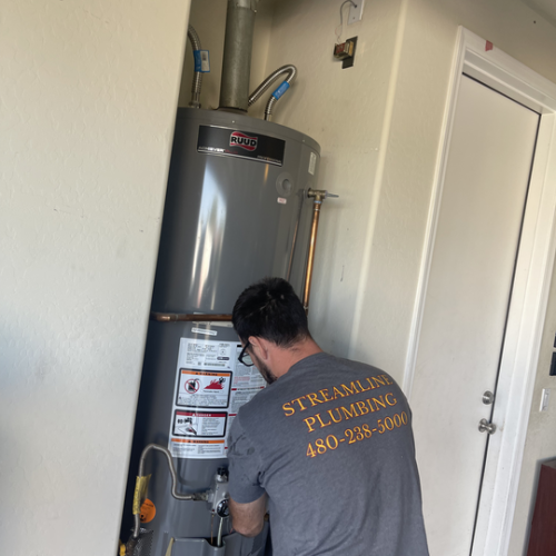 A standard tank water heater installed in a utility room.